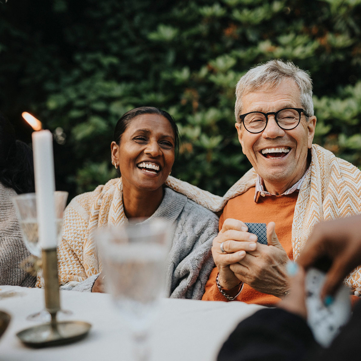 Older couple playing cards outdoors