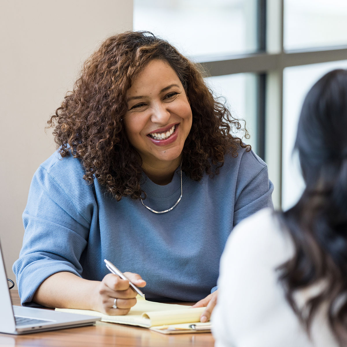 Woman writing in notebook and smiling
